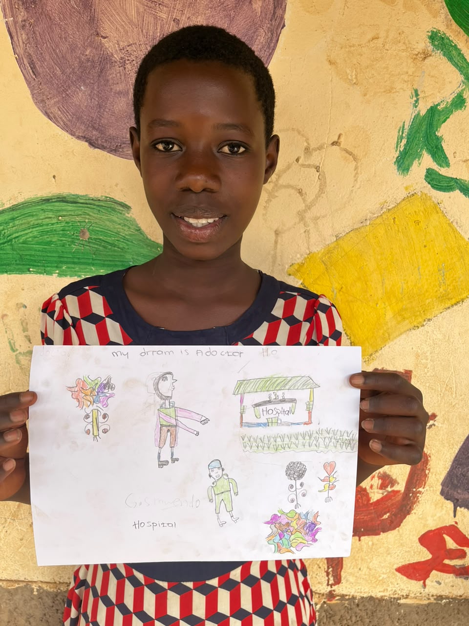 A child of the Inzozi Learning Center holding their dream drawing (6)
