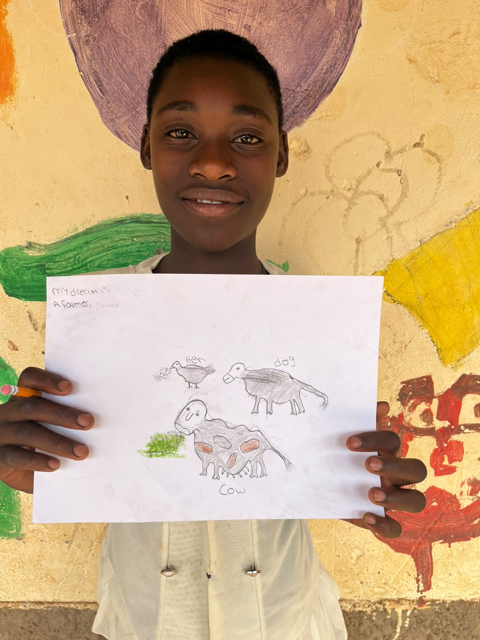 A child of the Inzozi Learning Center holding their dream drawing (3)