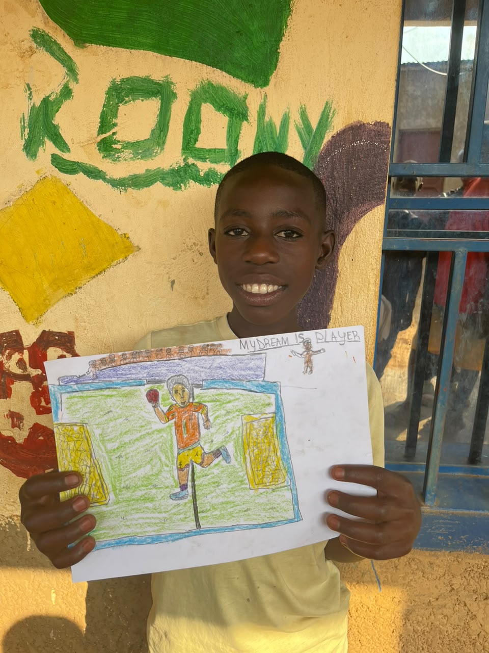 A child of the Inzozi Learning Center holding their dream drawing (15)