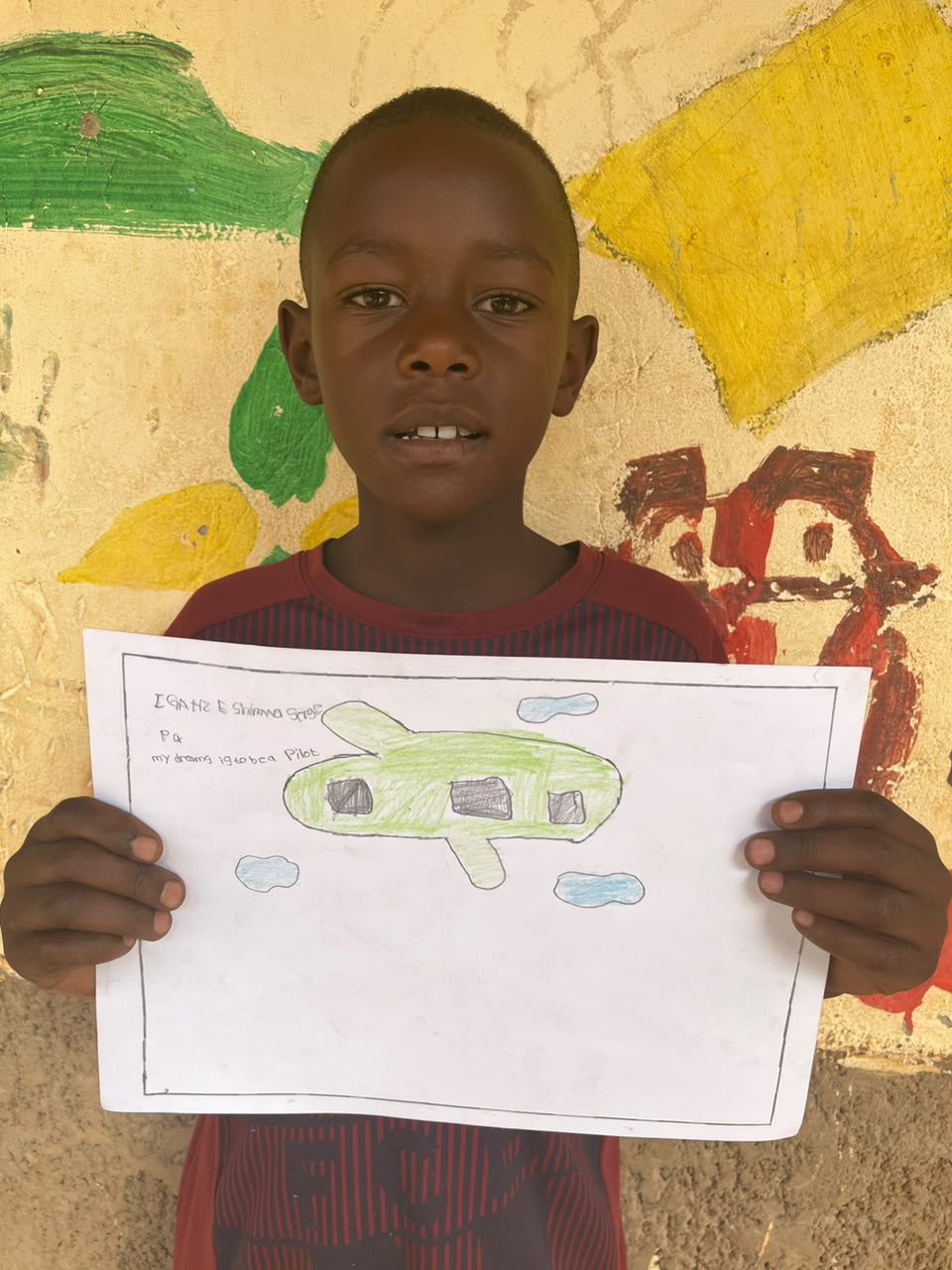 A child of the Inzozi Learning Center holding their dream drawing (9)