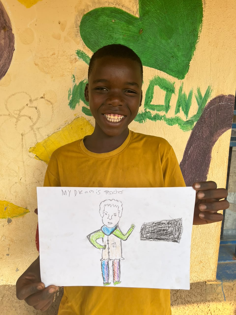 A child of the Inzozi Learning Center holding their dream drawing (14)