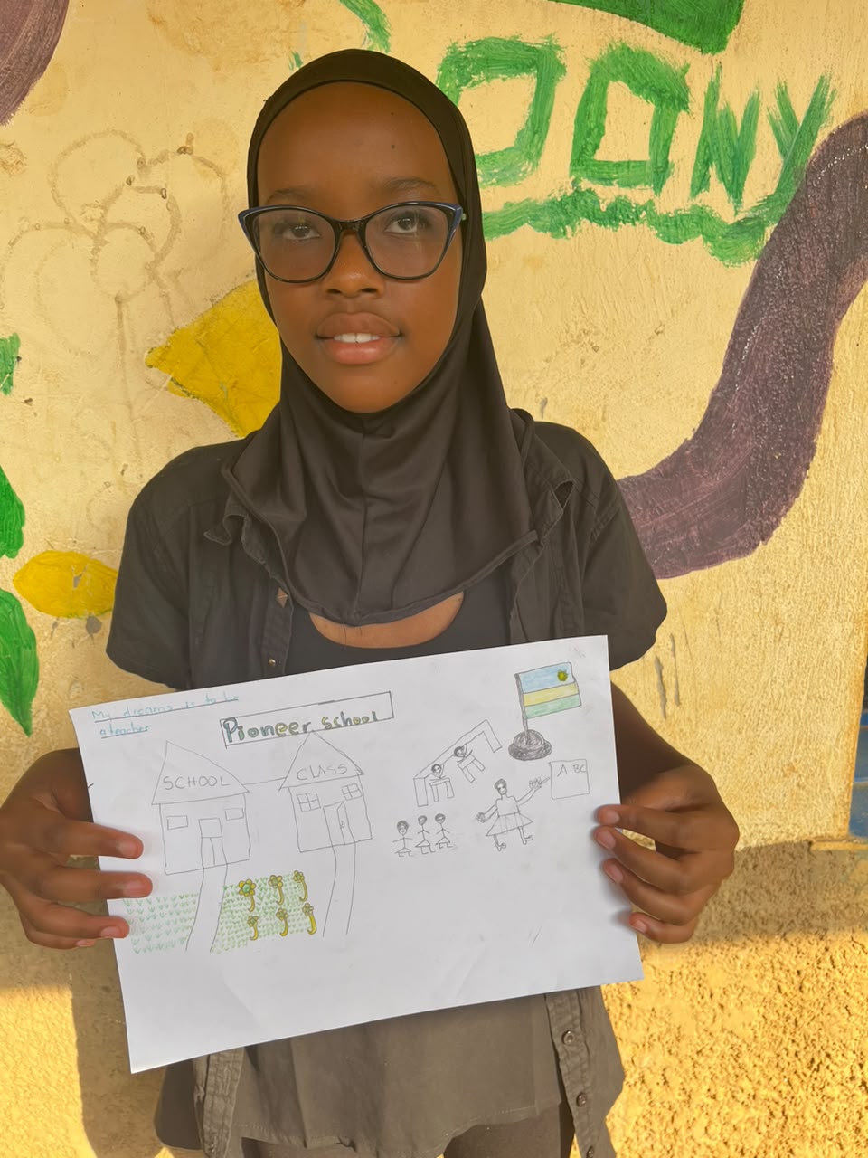 A child of the Inzozi Learning Center holding their dream drawing (13)