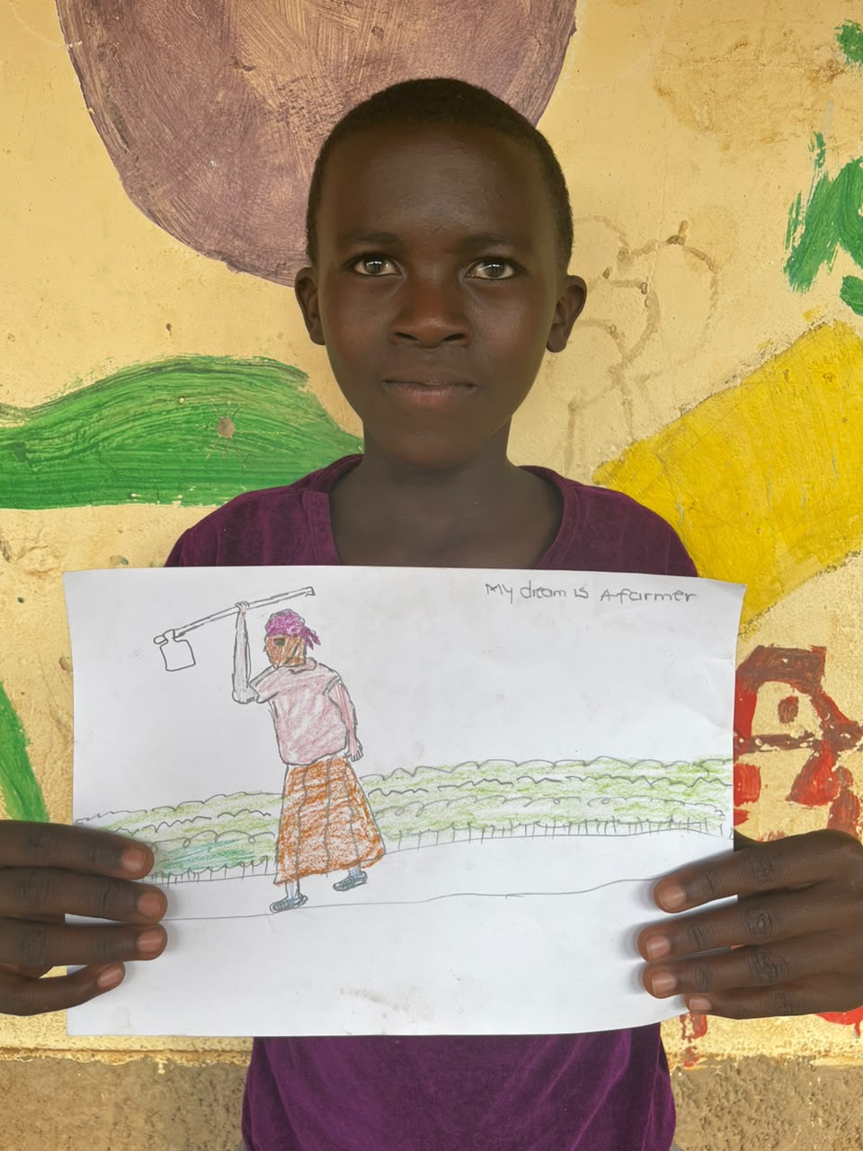 A child of the Inzozi Learning Center holding their dream drawing (1)