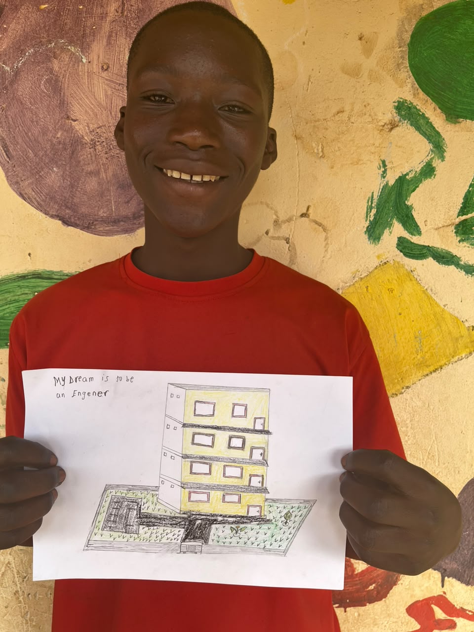 A child of the Inzozi Learning Center holding their dream drawing (7)