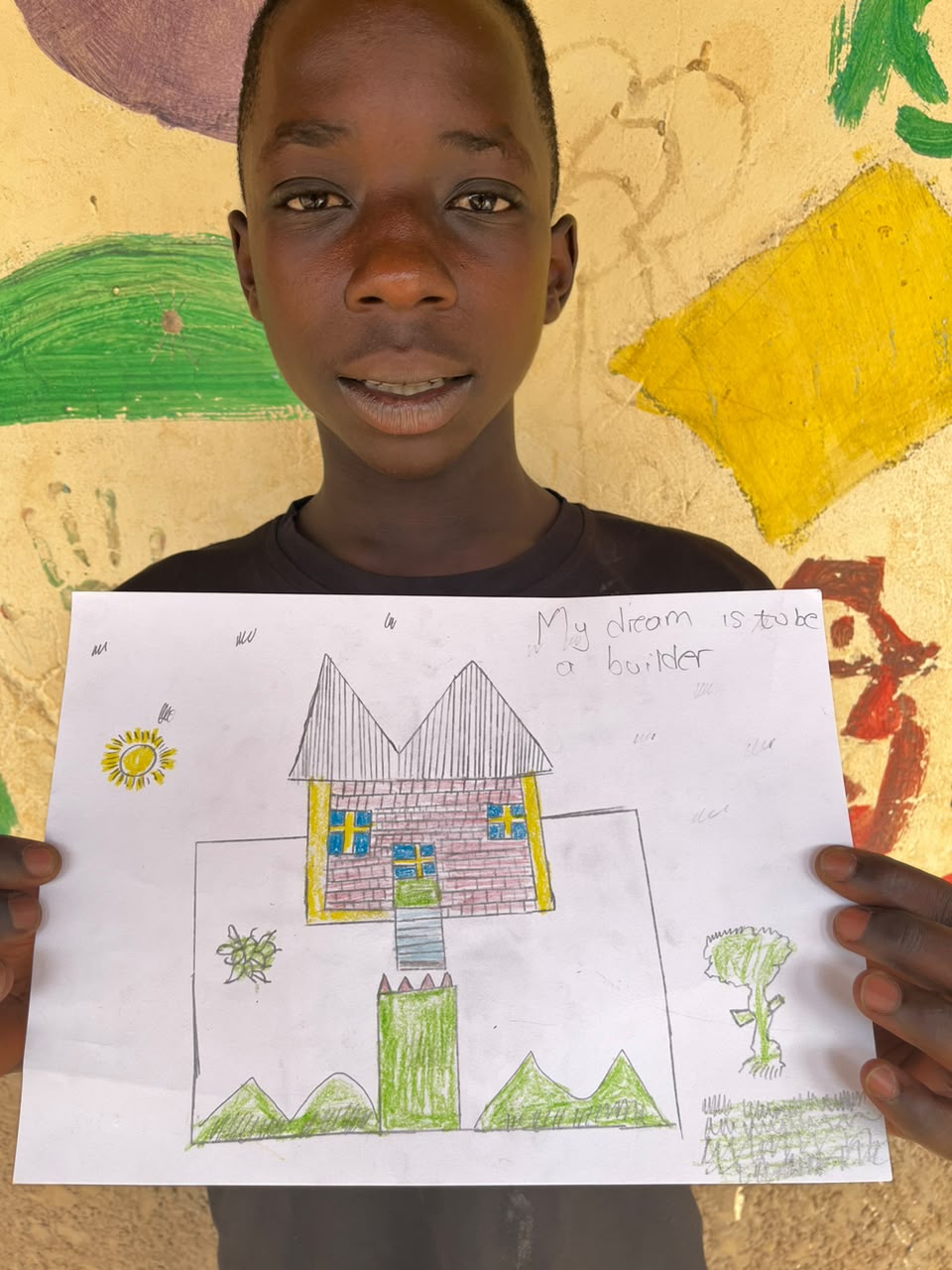 A child of the Inzozi Learning Center holding their dream drawing (4)